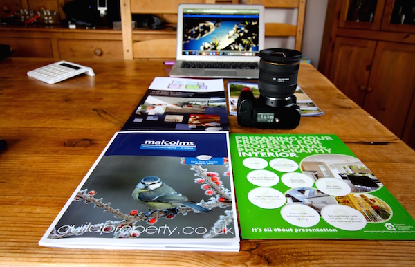 Property marketing material: magazines, camera, laptop