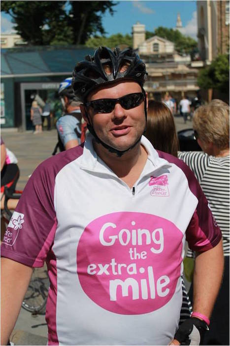 Cyclists wearing helmet and t-shirt promoting children's cancer charity