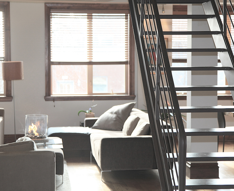 Loft style living room with sofa and stairway. 