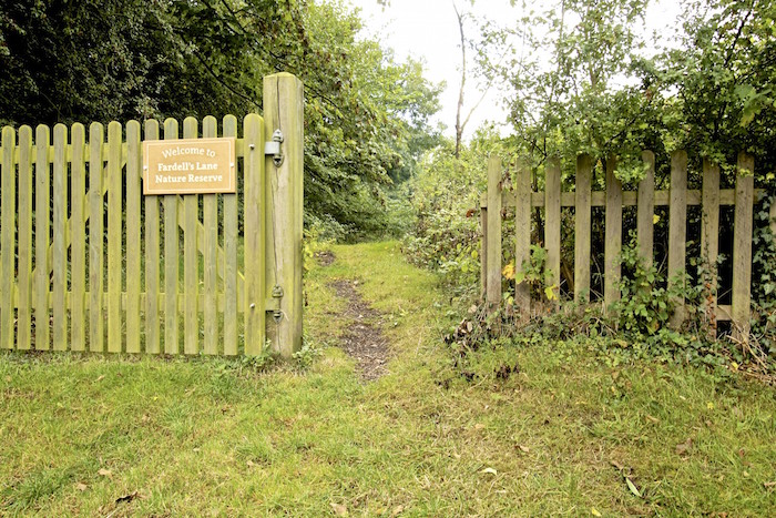Open wooden gate to nature reserve