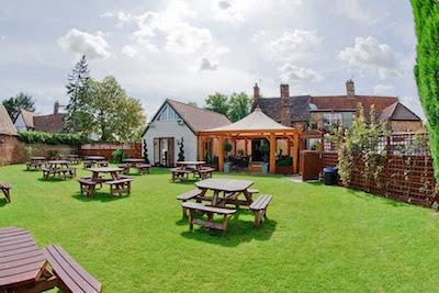 Garden with tables and chairs at The White Hart pub and gastro restaurant, Cambridge Street, Godmanchester
