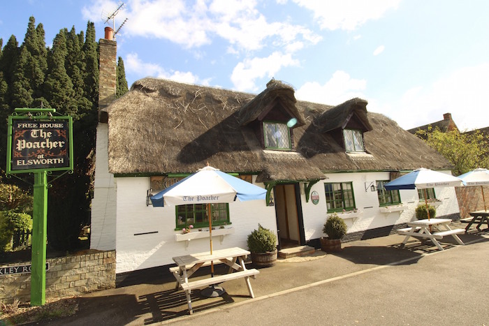 Restaurant with thatched roof and garden tables outside